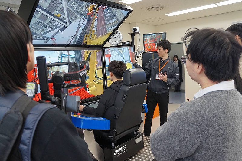 掘削機器のシミュレーターを操作する様子を撮影した写真です。